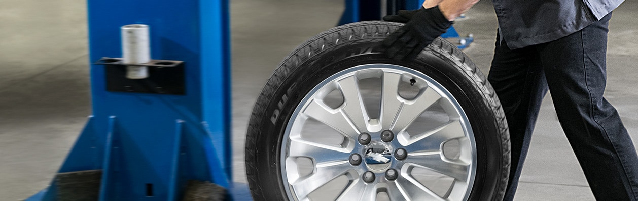 service tech rolling a tire